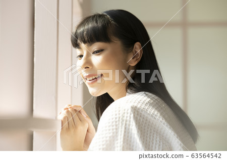A woman relaxing at the window side A woman relaxing at the window side 63564542
