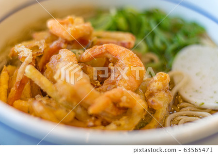 Blue and white ceramic bowl with hot udon noodles with tempura prawn and vegetables. Lunchtime in Kanazawa, Ishikawa Prefecture, Western Japan. 63565471