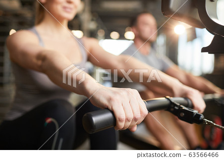 Woman Using Exercise Machine in Gym 63566466