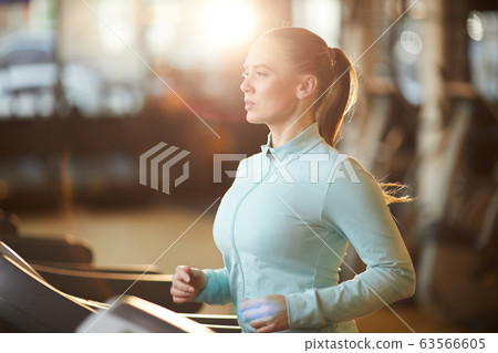 Young Woman on Treadmill in Gym 63566605