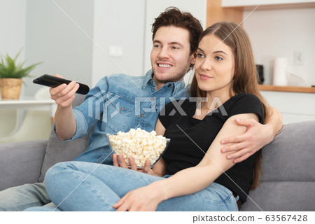 Young couple watching TV on sofa 63567428