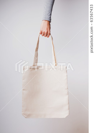 Woman's hand holds blank cotton eco tote bag, Woman's hand holds blank cotton eco tote bag, 63567433