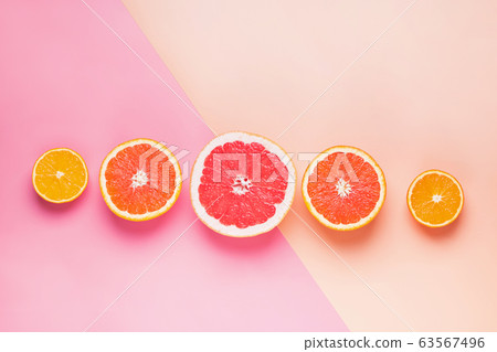 Slices of different citrus fruits on pink background Slices of different citrus fruits on pink background 63567496