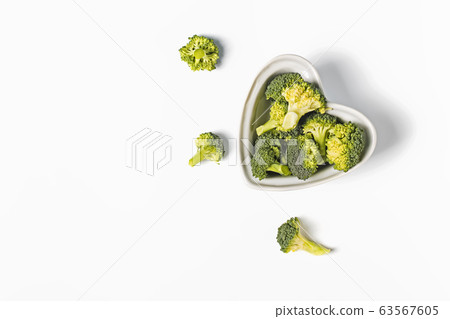 Raw broccoli in a heart shaped bowl on white background, Raw broccoli in a heart shaped bowl on white background, 63567605