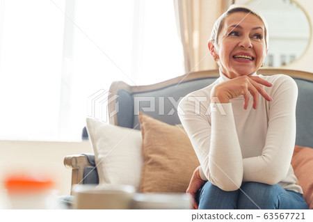 Attractive cheerful short-haired Caucasian woman looking aside 63567721
