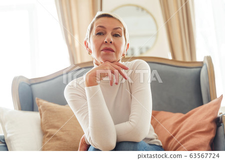 Modern elderly lady sitting on the couch Modern elderly lady sitting on the couch 63567724