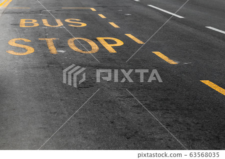 Yellow bus stop marking over urban asphalt road Yellow bus stop marking over urban asphalt road 63568035