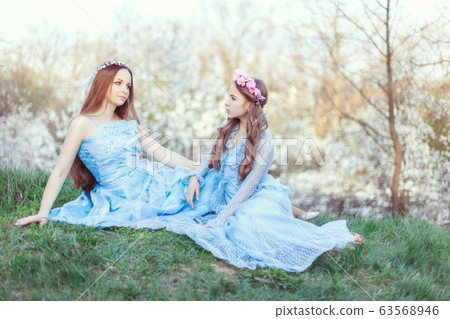 Attractive mom and daughter among blooming white 63568946