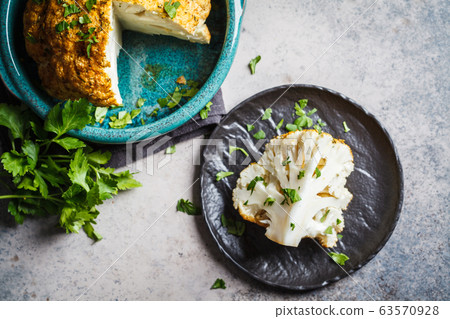 Whole baked cauliflower with spices and parsley Whole baked cauliflower with spices and parsley 63570928