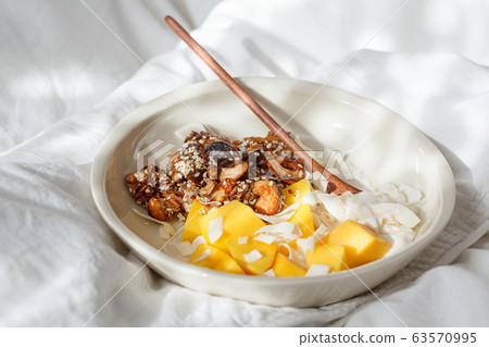Breakfast in bed - homemade granola, yogurt and mango Breakfast in bed - homemade granola, yogurt and mango 63570995