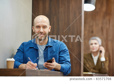 Bald Adult Man Smiling at Cafe Table 63571708