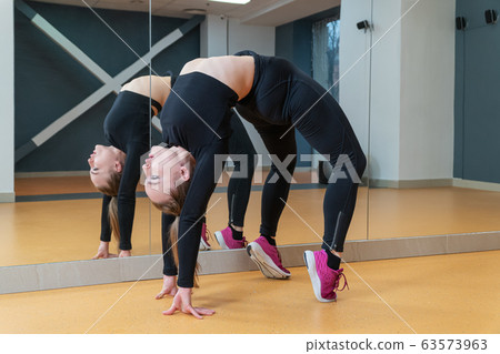 gymnastic bridge performed by a beautiful woman 63573963