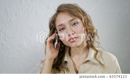 Portrait of blonde girl. Model posing for a photographer. 63574123