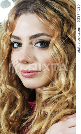 Girl is blonde with curly hair in a dark cherry turtleneck. 63574159
