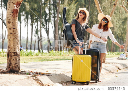 Female travelers catchig car Female travelers catchig car 63574343