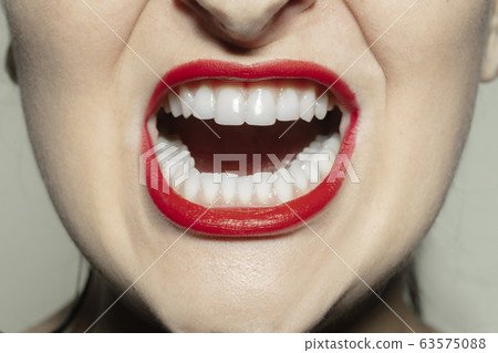 Close-up female mouth with bright red gloss lips make-up. Cosmetology, dentistry and beauty care, emotions 63575088