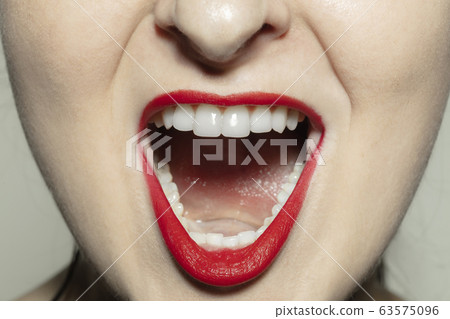 Close-up female mouth with bright red gloss lips make-up. Cosmetology, dentistry and beauty care, emotions 63575096