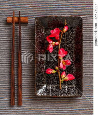 Chopsticks, rectangular plate and pink flowers on 63575097