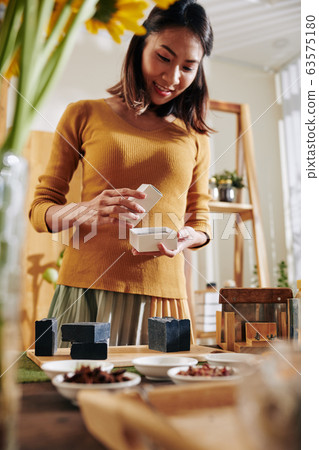 Woman packing black handmade soap Woman packing black handmade soap 63575180