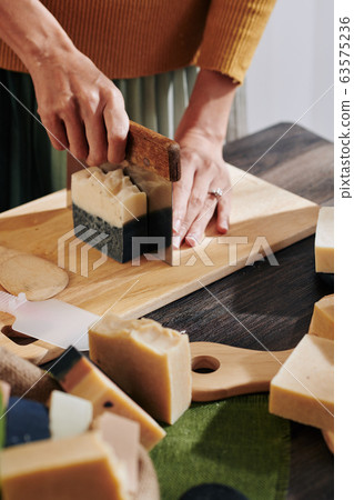 Woman cutting soap bar 63575236