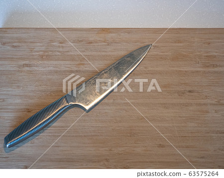 A large kitchen knife on a cutting board A large kitchen knife on a cutting board 63575264