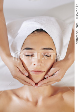 Beautician applying rejuvenating treatment 63575316