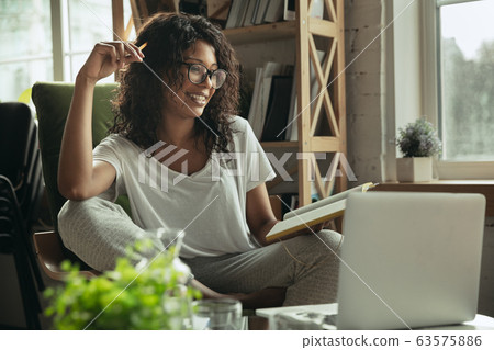 African-american woman, freelancer during the work in home office while quarantine 63575886