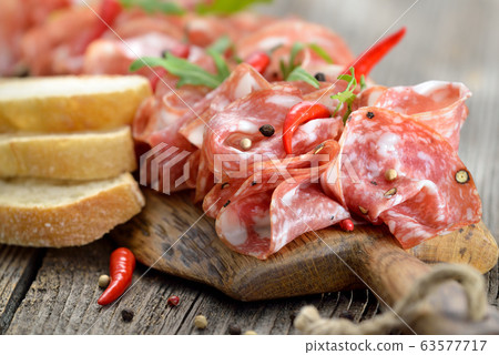Air-dried Italian salami from Tuscany served on a wooden board with ciabatta bread 63577717