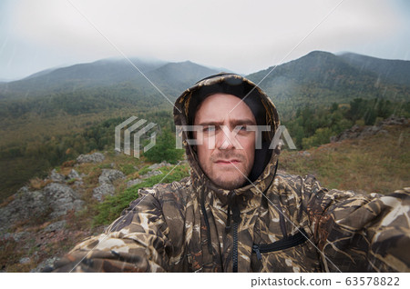 Caucasian man in the mountain making selfie 63578822