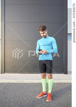 sportsman looking at the internet app on his sportsman looking at the internet app on his 63580670