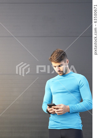 sportsman looking at the internet app on his sportsman looking at the internet app on his 63580671