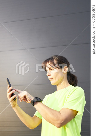 sportswoman looking at the internet app on his sportswoman looking at the internet app on his 63580672