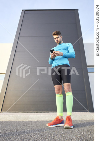 sportsman looking at the internet app on his sportsman looking at the internet app on his 63580674