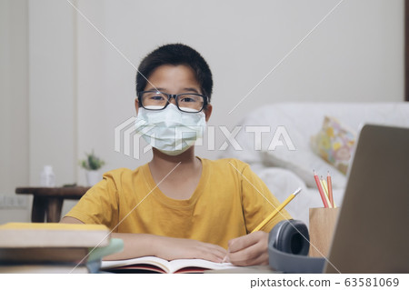 Boy wearing face masks online study at home. Boy wearing face masks online study at home. 63581069