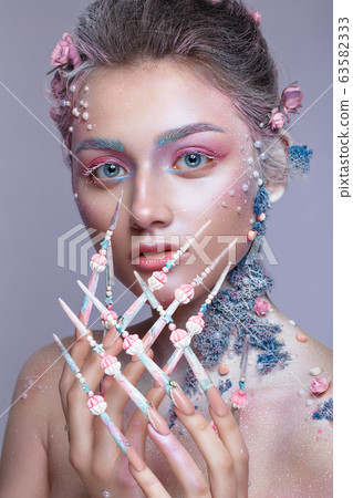 Beautiful girl in the image of a sweet fairy with art make-up and with long design nails. Creative manicure. 63582333