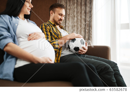 Husband with ball and his pregnant wife with belly Husband with ball and his pregnant wife with belly 63582678