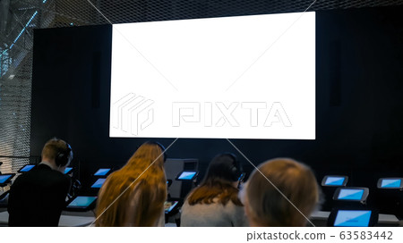 People looking at blank large interactive wall display - white screen concept 63583442
