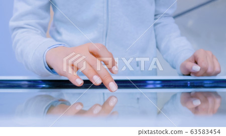 Woman using multimedia touchscreen display of interactive kiosk Woman using multimedia touchscreen display of interactive kiosk 63583454