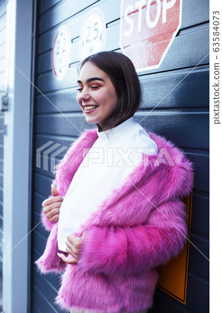 young cute girl teenager gesturing hanging around city parking and teasing with stop sign, lifestyle people concept 63584073