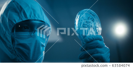 Scientist examining coronavirus sample in laboratory 63584074