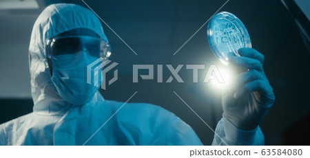 Scientist examining coronavirus sample in laboratory 63584080