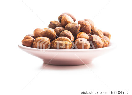Peeled hazelnuts on plate. 63584532