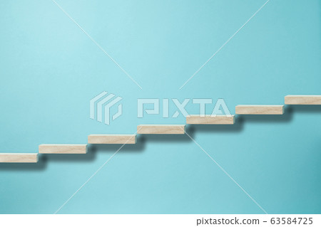 Building blocks lined up in a rising image on a light blue background Building blocks lined up in a rising image on a light blue background 63584725