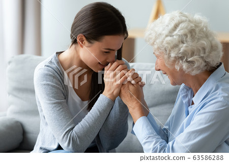 Millennial girl and middle-aged mom hold hands 63586288