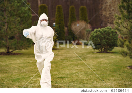 Person in a protective suit in a park 63586424