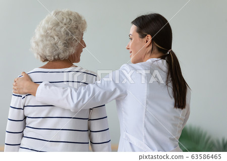 Back view of female nurse take care of old patient 63586465