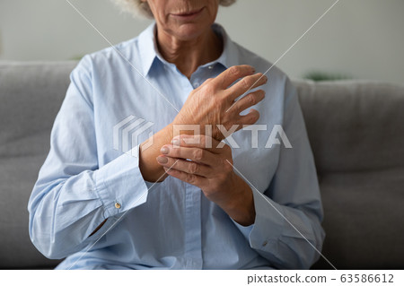 Sick senior woman check heart pulse on wrist 63586612