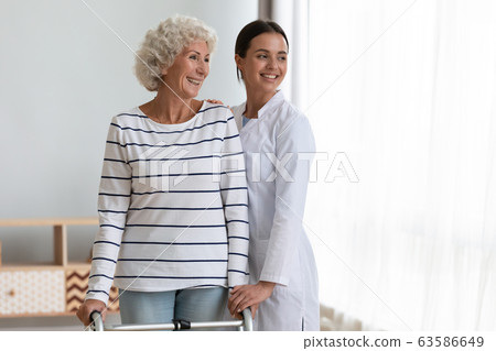 Smiling young nurse and mature patient feel hopeful for future 63586649