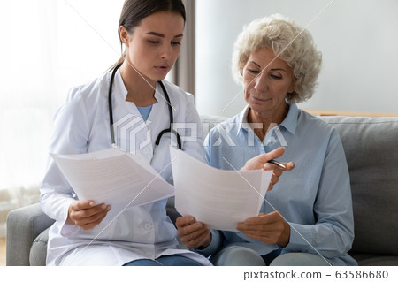 Woman doctor close health insurance with old lady patient 63586680