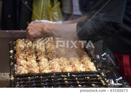 Vendor making takoyaki on a takoyaki pan in Osaka, Vendor making takoyaki on a takoyaki pan in Osaka, 63588873